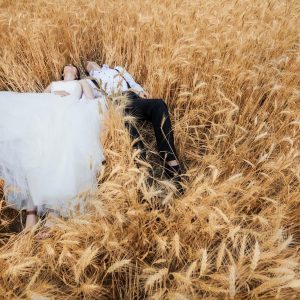 Bride and groom lying in wheat field